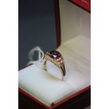 A 14ct rose gold ring set with garnet and white sapphires