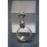 An unusual silver magnifying glass in the form of a hand on silver chain