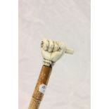 A vintage walking stick with carved ivory clenched fist possibly Masonic.