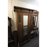 Arts and Crafts oak hall wardrobe with coppered stylised panels and single mirrored door