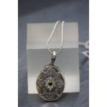 A silver oval locket on silver chain
