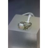 A silver opal and CZ three stone ring