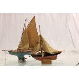 Two vintage wooden Pond Yachts with stands & sails, the larger one with an A W Gamage Holborn London