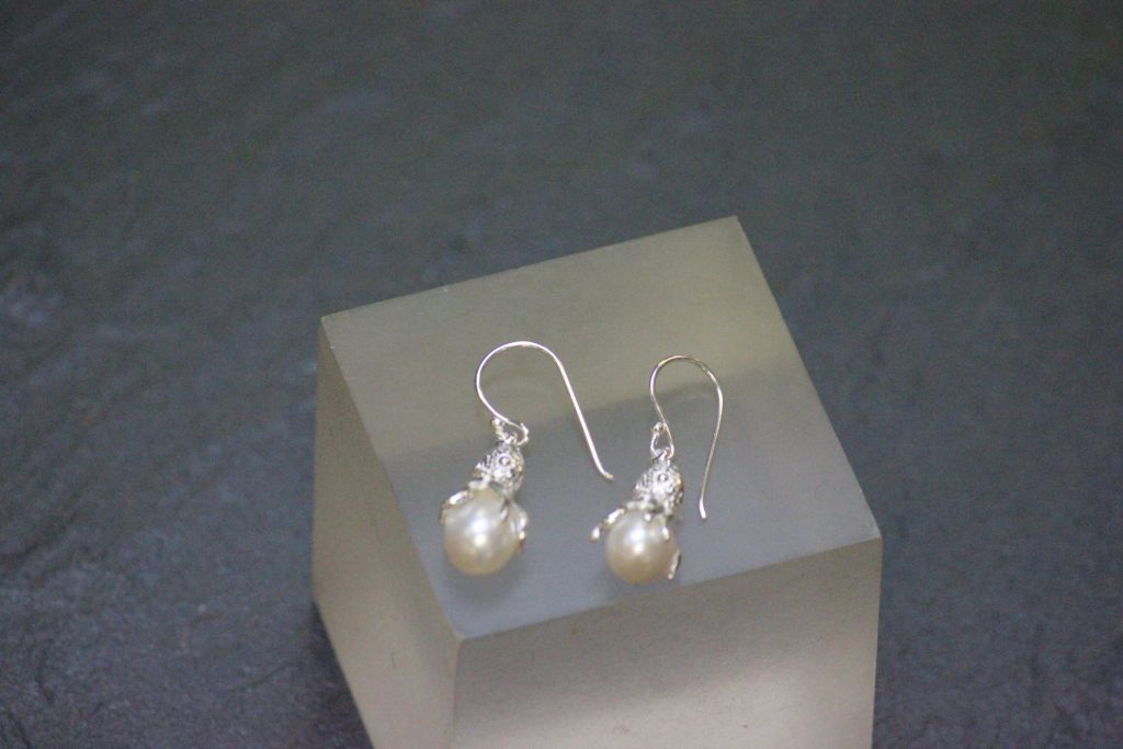 A pair of silver and freshwater pearl earrings in the form of a squid