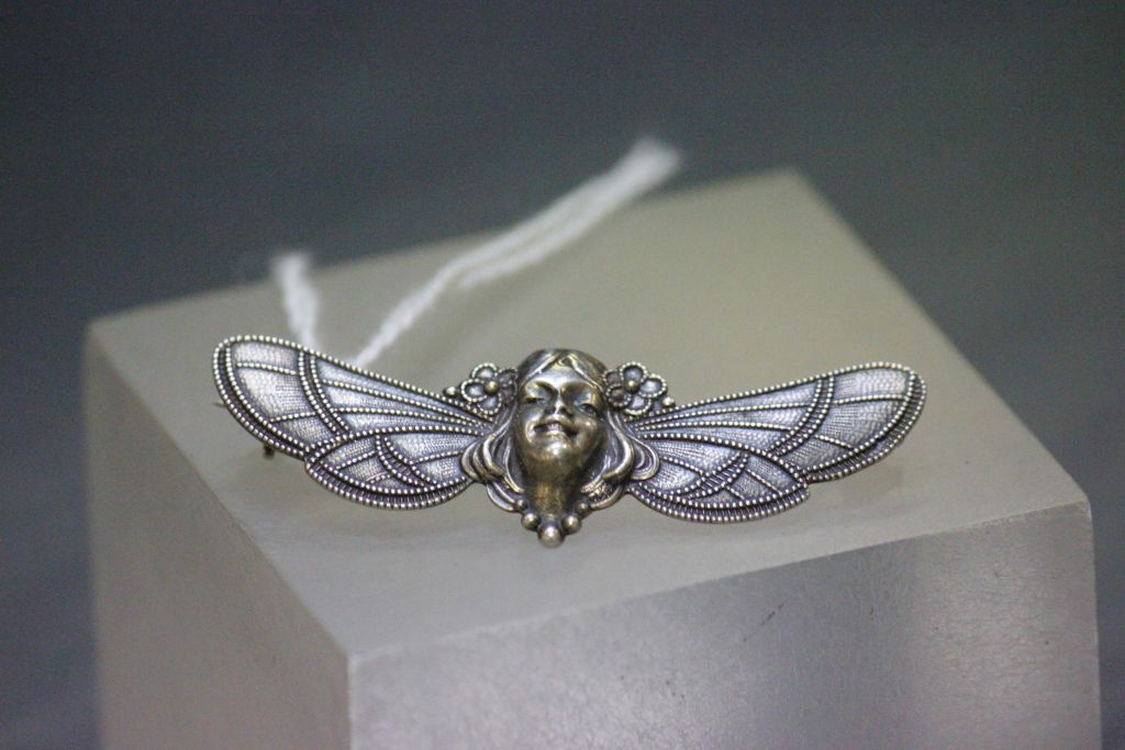 A vintage white metal brooch in the art nouveau style.