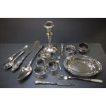 A collection of silver items including 7 napkin rings, single weighted candlestick, pierced dish and