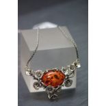 A silver and amber style pendant necklace on silver chain