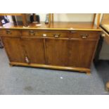 Regency style Yew wood sideboard with a cluster of 3 drawers to the front all above 4 cupboards