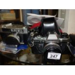 Olympus, a 35mmm camera model OM10, with instructions, and flash, 1 other leather cased camera by