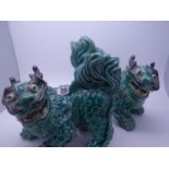 Pair of interesting antique Oriental green glazed figurines of firey beasts, biscuit porcelain, each