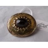 Victorian high carat brooch mounted with a cabochon garnet in fancy setting