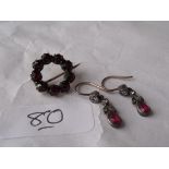 A small pair of antique drop ear pendants and a circular garnet set brooch