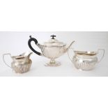 Silver teapot, sugar bowl and milk jug. An Edwardian silver teapot of lobed oval form on oval