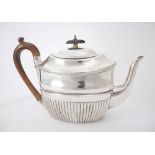 George III silver teapot. An early 19th century silver teapot, the waisted and semi reeded body,