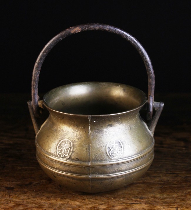 A Small 16th/17th Century Bronze Cauldron with iron swing handle looped through triangular lugs