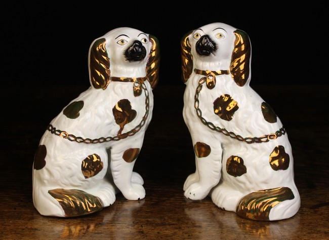 A Pair of Staffordshire Seated Spaniels modelled with separate front legs and decorated with