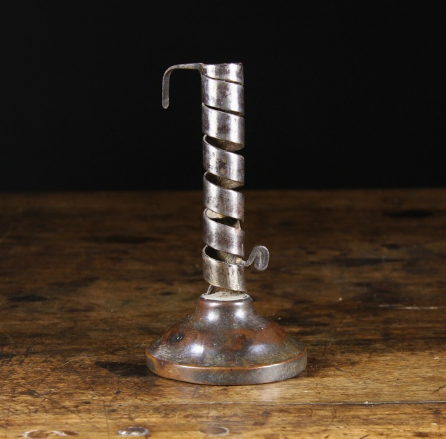 An Early 19th Century Coiled Strap Candlestick with height adjuster on a treen base,