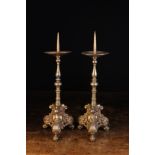 A Pair of Flemish Baroque Pricket Candlesticks with dished drip pans above knopped baluster stems