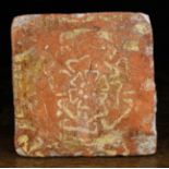 A 16th Century Terracotta Tile decorated with a Tudor rose, 5 ins (13 cms) square.