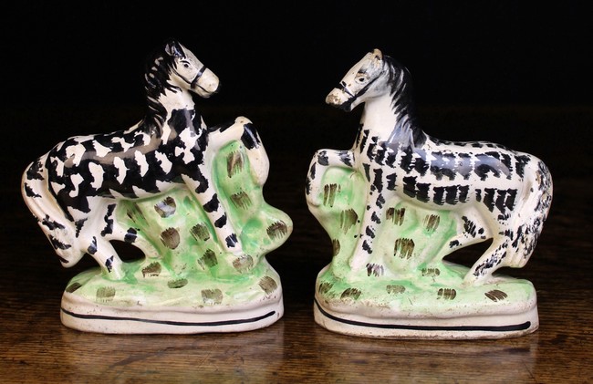 A Pair of 19th Century Staffordshire Zebras decorated with naive brushwork and standing on grassy