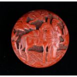 A 19th Century Carved Cinnabar Lacquered Manju Netsuke decorated with a figure in landscape to one
