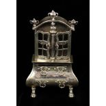 A Dutch Miniature Silver Cabinet with an upper cupboard of two doors surmounted by urn finials and