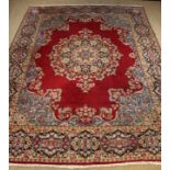 A Large 20th Century Iranian Wool Carpet with a large floral centre medallion on a claret ground,