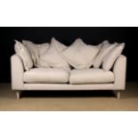 A Modern Sofa with six large loose feather filled back cushions covered in cream fabric,