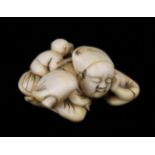 An 18th/19th Century Carved Ivory Netsuke in the form of a sleeping figure with a mischievous