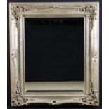A Large Bevelled Rectangular Wall Mirror in a decorative swept silver-giltwood frame with scrolling