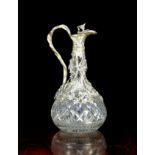 A Cut Glass Claret Jug with Silver Plated mounts cast with trailing vines and having a hinged lid