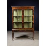 An Edwardian Mahogany Glazed Two-doored Display Cabinet inlaid with stringing.