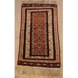A Small Turkish Wool Rug woven with six hexagonal medallions on a pale brown centre panel within a