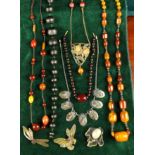 A Collection of Amber & Simulated Amber Necklaces and celluloid brooches etc.