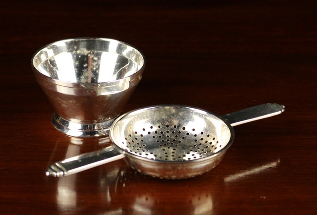 An Art Deco Silver Tea Strainer and dish.