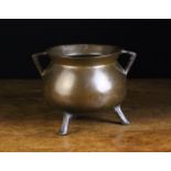 A Small 16th or 17th Century Bronze Cauldron with triangular lug handles and reeded legs,