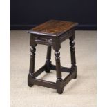 A 17th Century Joint Stool with chip carved rails on twin ball knopped column legs united by