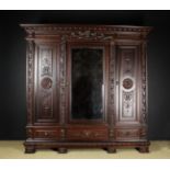 A French Neo-Renaissance Style Triple Wardrobe carved with a frieze band of overlapped scales and