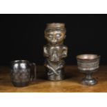 Three Fine Carved Kula Goblets: One in the form of a man sat cross-legged holding a flask,