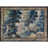 A 17th Century Verdure Tapestry with a huntsman and dog walking woodland,