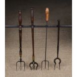 Four 19th Century Toasting Forks with turned treen handles: A three pronged iron fork with