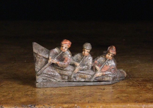 A 16th Century Carved Wooden Miniature Fragment depicting three musicians leant over a gallery