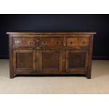 A Joined Oak Dresser Base (A/F) fitted with three frieze drawers above cupboard doors,