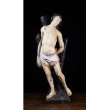 A Late 17th/Early 18th Century Polychrome Carving of Saint Sebastian pierced with arrows,