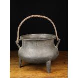 A 17th or 18th Century Bronze Cauldron having a wrought iron swing handle looped through triangular