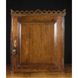 A Fine 18th Century Oak Wall Cupboard. The top surmounted by a pierced & scalloped gallery rail.