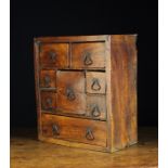 An 18th Century Rustic Elm Spice Cabinet fitted with various sized drawers centred by iron loop