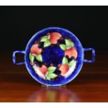 A Moorcroft Twin-handled Dish decorated with pomegranates on a deep blue ground,