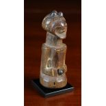 An African Doll or Fetish Figure possibly Luba, 3½ in (16 cm) high, on a metal stand.