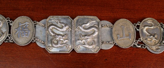 A Chinese Silver Belt composed of linked oval medallions cast with scrolling dragons alternated